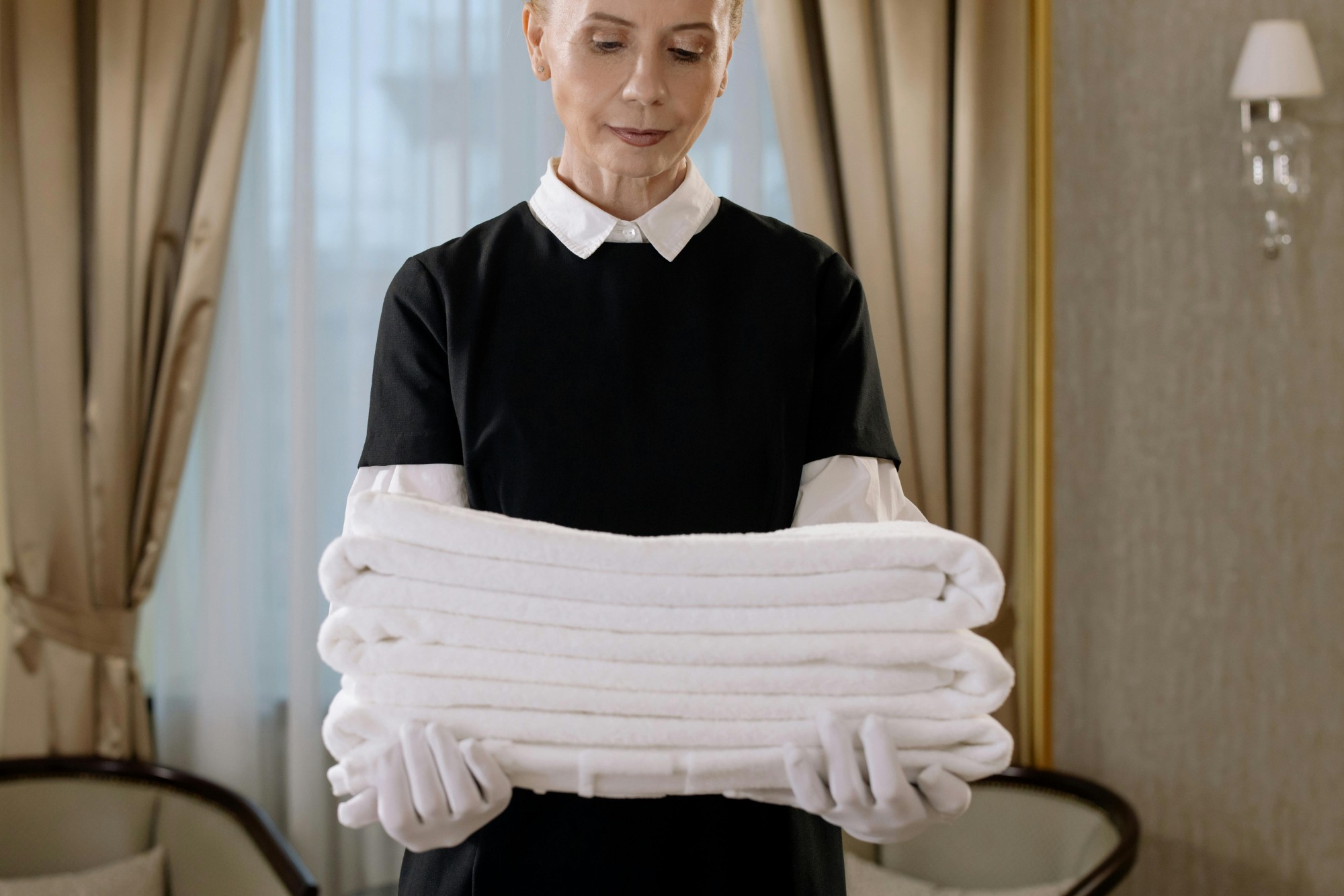 Professional cleaner in Rhode Island wearing eco-friendly uniform, using green products for sustainable cleaning service.