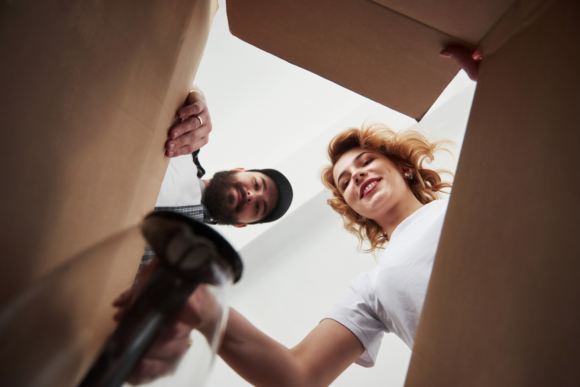 Happy family unpacking boxes and arranging decorations in their new, freshly cleaned home, symbolizing a fresh start and the importance of a clean living environment during a move.