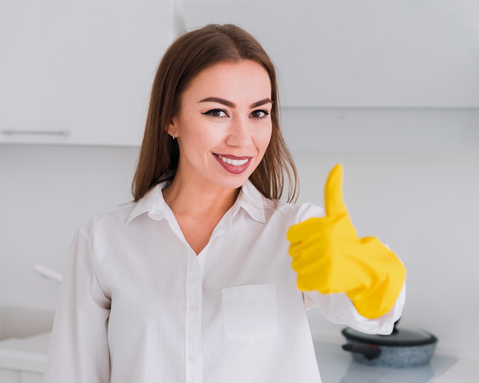 A female cleaner wearing gloves and giving a thumbs up, representing the high-quality service provided by Sun Pristine Maids